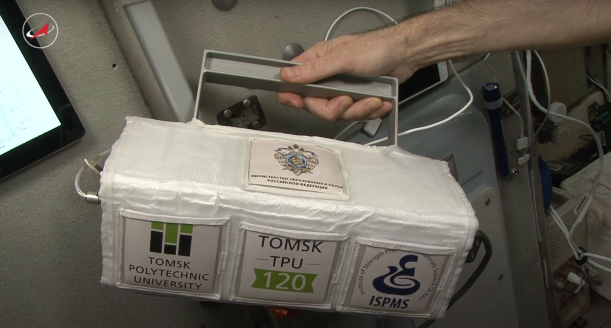 The Tomsk-TPU-120 microsatellite held by an astronaut on the International Space Station
